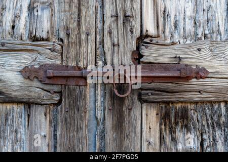 Detail eines rostigen eisernen Bolzenschlosses an der alten Holztür. Nahaufnahme Stockfoto