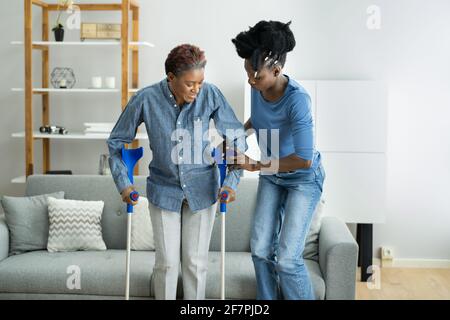 Hilfe Für Verletzte Behinderte Afrikanerin Mit Krücken Stockfoto