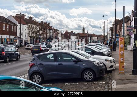 Geschäftiger Tag auf den Straßen mit starkem Verkehr und Autos, die in der High Street, Yarm, England, Großbritannien, geparkt sind Stockfoto