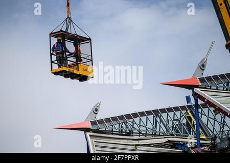 Zwei Bauarbeiter arbeiten in einem Krankäfig in schwindelerregender Höhe auf den Resten der Haupttribünen des Wildpark-Stadions, das derzeit abgebaut wird. GES / Fußball / Bauarbeiten Wildparkstadion Karlsruhe, 9. April 2021 Fußball / Fußball: 2. Deutsche Liga: KSC-Wildparkstadion im Bau, 09. April 2021 weltweit im Einsatz Stockfoto