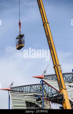 Zwei Bauarbeiter arbeiten in einem Krankäfig in schwindelerregender Höhe auf den Resten der Haupttribünen des Wildpark-Stadions, das derzeit abgebaut wird. GES / Fußball / Bauarbeiten Wildparkstadion Karlsruhe, 9. April 2021 Fußball / Fußball: 2. Deutsche Liga: KSC-Wildparkstadion im Bau, 09. April 2021 weltweit im Einsatz Stockfoto