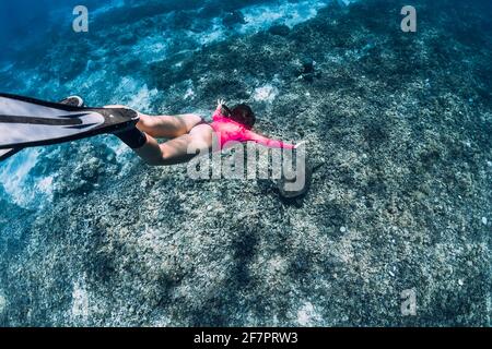 Frau taucht unter Wasser mit Schildkröte im tropischen Ozean. Schnorcheln mit einer grünen Meeresschildkröte. Stockfoto