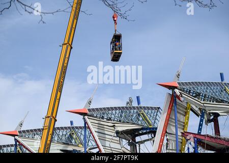 Karlsruhe, Deutschland. April 2021. Zwei Bauarbeiter arbeiten in einem Krankäfig in schwindelerregender Höhe auf den Resten der Haupttribünen des Wildpark-Stadions, das derzeit abgebaut wird. GES/Fußball/Bauarbeiten Wildparkstadion Karlsruhe, 9. April 2021 Fußball/Fußball: 2. Deutsche Liga: KSC-Wildparkstadion im Bau, 09. April 2021 weltweite Nutzung Kredit: dpa/Alamy Live News Kredit: dpa picture Alliance/Alamy Live News Stockfoto
