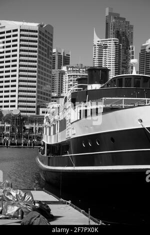 Darling Harbour Blick auf die Stadt und das Stadtbild. Ein altes Boot mit der Stadt dahinter. Stockfoto