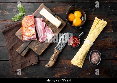 Zutaten für Pasta Carbonara. Traditionelles italienisches Essensset, auf einem alten dunklen Holztisch, von oben gesehen flach liegend Stockfoto