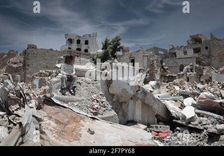 Taiz   Jemen   13 Apr 2017 : EIN trauriges Kind sitzt auf den Trümmern seines Hauses, das durch den Krieg im Jemen, Taiz, zerstört wurde Stockfoto