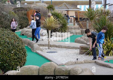 Hastings, East Sussex, Großbritannien. 09 April 2021. UK Wetter: Sonnige Intervalle an der Strandpromenade von Hastings, die sehr voll mit Familien ist. Viele Leute spielen verrücktes Golf. Foto-Kredit: Paul Lawrenson /Alamy Live Nachrichten Stockfoto