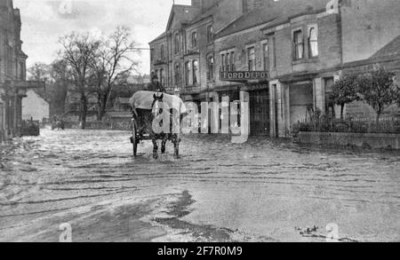 Archivfoto in Schwarzweiß, aufgenommen Anfang des 20. Jahrhunderts, das Überschwemmungen im Zentrum von Matlock, einer Stadt im Derbyshire Peak District England, zeigt. Stockfoto