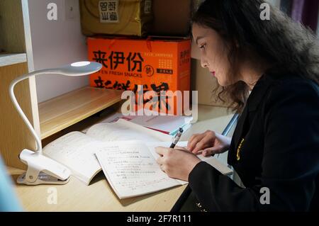 (210409) -- SHANGHAI, 9. April 2021 (Xinhua) -- Risalet Ehmet studiert an ihrem Schlafsaal in der Lixin University of Accounting and Finance in Shanghai, Ostchina, 7. April 2021. Risalet Ehmet, 19, stammt aus dem Bezirk Zepu in Kashgar, nordwestlich der Autonomen Region Xinjiang Uygur in China. Heute studiert sie an der School of Information Management der Shanghai Lixin University of Accounting and Finance. Mit Hilfe von Lehrern und Mitschülern passte sie sich schnell an das Universitätsleben an. „nach dem Studium werde ich das Gelernte nutzen, um die Spezialitäten meiner Heimat zu bewerben Stockfoto