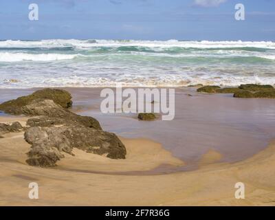 Der Sandstrand in der Stadt Wilderness, an der Südküste Südafrikas, am späten Morgen mit dem Sand noch nass von den sich zurückziehenden Wellen Stockfoto