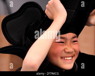 (210409) -- DENGFENG, 9. April 2021 (Xinhua) -- Fang Yuhao von der Shaolin Tagou Eishockey-Mannschaft hebt seine Ausrüstung nach einer Trainingseinheit in der Shaolin Tagou Martial Arts School, Stadt Dengfeng, Provinz Henan in Zentralchina, 31. März 2021 ab. Die Shaolin Tagou Martial Arts School, wenige Kilometer vom Shaolin-Tempel entfernt, dem Geburtsort von Shaolin Kung Fu, baut ihr Eishockey-Team auf. Die Schüler lernen den Sport auf Rollschuhlaufen auf einer normal großen, mit Boden bedeckten Eisbahn. Das Üben der Kampfkunst stärkt ihre Physiken und verleiht ihnen sportliche Qualitäten, die Eis sind Stockfoto