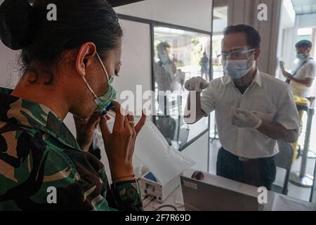 Eine Frau bläst Luft in eine Plastiktüte, um mit einer GeNose C19 (GeNose), einem COVID-19-Erkennungswerkzeug am Gusti Ngurah Rai International Airport, auf die Coronavirus-Krankheit (COVID-19) getestet zu werden. Gusti Ngurah Rai International Airport übernimmt den Coronavirus-Test GeNose C19, um die Wiedereröffnung des Tourismus vorzubereiten. GeNose C19 ist eine künstliche Intelligenz, die auf einer Atemtestmethode basiert, die von der indonesischen Universität Gajah Mada, Yogyakarta, entwickelt wurde. (Foto von Dicky Bisinglasi / SOPA Images/Sipa USA) Stockfoto