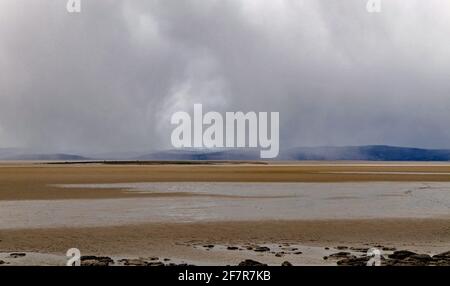 An einem kalten Frühlingstag fällt Schnee über den Sand der Morecambe Bay vor der Nordwestküste Englands, Blick von der HEST Bank. Stockfoto