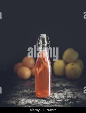 Isolierte Flasche hausgemachter Kombucha, ein Brühfruchttee mit Probiotika, Bakterien und Hefe. Zweite Gärung mit Erdbeeren und Minze mit Jahrgang Stockfoto