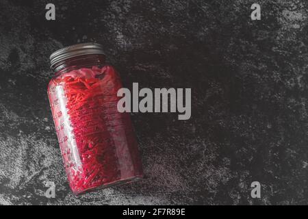 Dunkle launische Food-Fotografie von einem Glas mit hausgemachtem fermentiertem Rotkohl-Chucrut. Standbild mit Kopierplatz. Stockfoto
