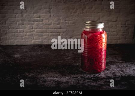 Dunkle launische Food-Fotografie von einem Glas mit hausgemachtem fermentiertem Rotkohl-Chucrut. Standbild mit Kopierplatz. Stockfoto