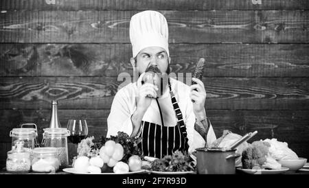 In der Liebe zu gesunden Lebensmitteln. Hunger und Appetit. Gesundes vegetarisches Rezept. Mann bärtige Hipster Hut und Schürze Kochen gesunde Lebensmittel. Vegetarisch Stockfoto