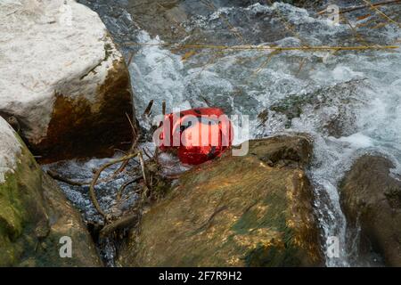 Ein roter Ballon mit gezogenem Gesicht und Schnurrbart schwebt auf der Wasseroberfläche Stockfoto
