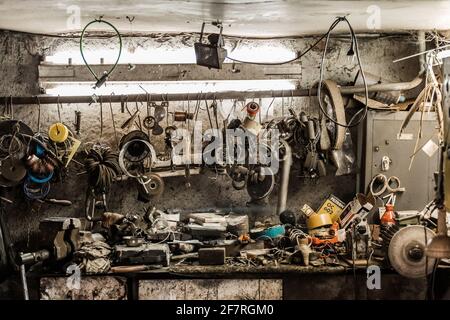 Weißrussland, Minsk - 06. Februar 2020: Schmutziges Werkstattregal mit Arbeitsgerät im Hintergrund eines Industriebetriebes. Stockfoto