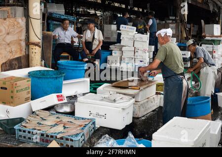 Horizontale Ansicht einiger Fischhändler, die im Großhandelsgebiet für Meeresfrüchte mit Zwischenprodukt, Tsukiji Market, Tsukiji, Tokio, Japan, tätig sind Stockfoto