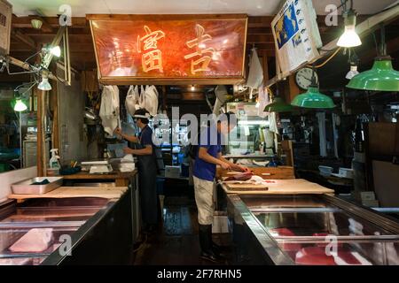 Horizontale Ansicht von zwei japanischen Fischhändlern, die im Innenbereich des Seafood Intermediate Wholesalers arbeiten, Tsukiji Market, Tsukiji, Tokio, Japan Stockfoto