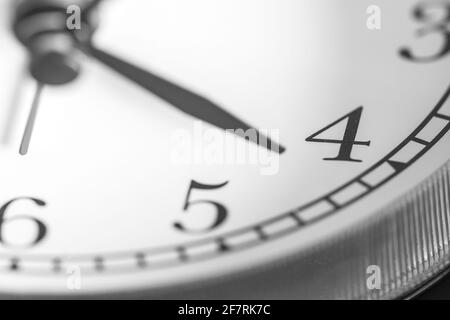 Zeigeuhr zeigt vier Uhr auf weißem Ziffernblatt von Klassischer Wecker mit zwei Glocken Stockfoto