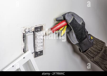 Ein Elektriker sucht nach einer Störung mit einer Phase suchen Sie die Sonde im Lüfterrelais Stockfoto