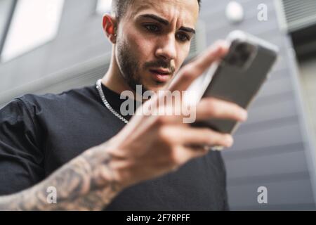 Spanischer Mann, der ein Telefon im Freien benutzt Stockfoto