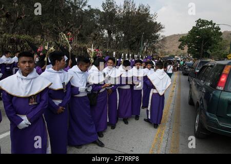 Cucuruchos in lila Gewändern werden feierlich durch die Straßen von Antigua, Guatemala, während der traditionellen Feierlichkeiten der Weihnachtsfeier in der Karwoche Semana gefeiert. Stockfoto