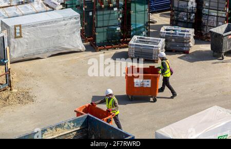 Zwei Arbeiter in gut sichtbarer Kleidung und weißen Helmen auf einer Baustelle. London. Stockfoto