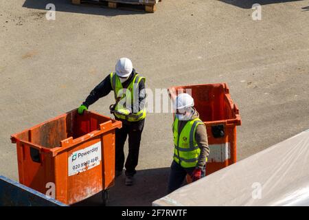 Zwei Arbeiter in gut sichtbarer Kleidung und weißen Helmen auf einer Baustelle. London. Stockfoto