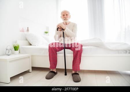 Ganzkörper-Foto von älteren Mann Rentner unglücklich traurig aufgeregt Allein denken, sitzen schlecht zu Hause drinnen halten Walking Stick Stockfoto