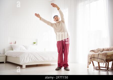 Ganzkörper-Foto von älteren Mann Rentner glücklich positiv genießen Machen Sie morgens sportliches Training in Innenräumen Stockfoto