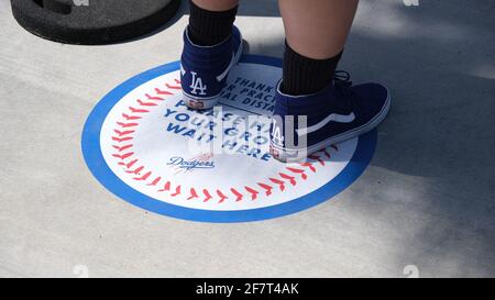 Los Angeles, CA, USA. April 2021. Ein Fan steht auf einer „sozialen Distanz“-Markierung, während er am Freitag beim Eröffnungsspiel von Dodgers gegen die Nationals in der Schlange steht. Die Dodgers eröffneten das Stadion zum ersten Mal seit 18 Monaten mit neuen COVID-19-Fan-Richtlinien einschließlich sozialer Distanzierungsrichtlinien. Quelle: Young G. Kim/Alamy Live News Stockfoto