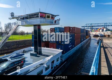 Containerschiff fährt in das Hafenbecken des Logports, Portalkrane im Containerumschlagzentrum, trimodaler Containerterminal, am logP Stockfoto