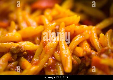 Detail eines Tellers mit Trofie a la Bolognesa, hausgemachter italienischer Pasta mit Tomaten, Karotten und Käse Stockfoto