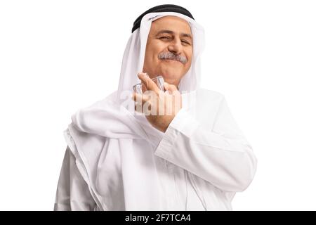 Arabischer Mann in weißem Spülstrich, der ein isoliertes Parfüm sprüht Weißer Hintergrund Stockfoto