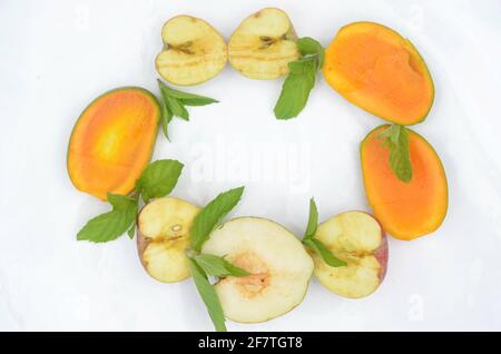 Draufsicht auf geschnittenen Mangos, Äpfeln, Minzblättern und Birnen auf weißem Hintergrund isoliert Stockfoto