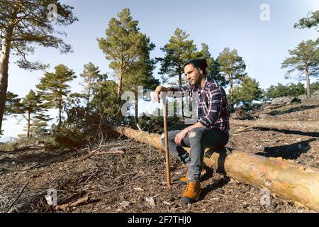 Der Holzfäller macht während der Arbeit in eine Pause Die holzige Terrakotta Stockfoto