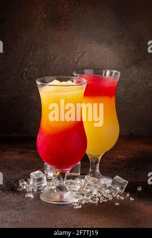 Leckere kalte erfrischende bunte Smoothie-Getränke in Cocktailglätten mit Früchten Stockfoto