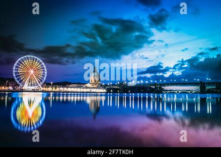 Toulouse, Österreich, Frankreich; 21. Juli 2018: Sonnenuntergang über dem Fluss Garone mit dem Krankenhaus, der Saint-Pierre-Brücke und dem Riesenrad auf der anderen Stockfoto
