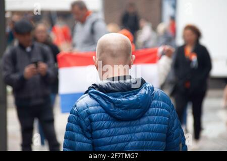 Amsterdam, Niederlande - 27. April 2019: Mann mit Holländer im Hintergrund. Stockfoto