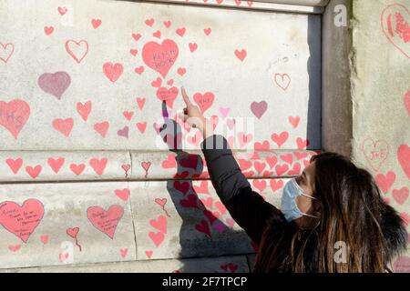 Die nationale Covid Memorial Wall neben der Themse in London. Rote Herzen von wurden an die Wand als Hommage an die Opfer des Virus gemalt. Stockfoto