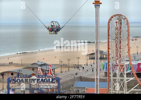 New York, USA. April 2021. Von der Innenseite einer Wonder Wheel-Kabine aus gesehen, werden Menschen während der Sling Shot-Fahrt am Tag der Wiedereröffnung der Vergnügungsparks von Coney Island im Stadtteil Brooklyn von New York City, NY, am 9. April 2021 in die Luft geschossen. Seit Oktober 19 geschlossen, haben die Parks zu 33 % wieder geöffnet und Besucher müssen Masken tragen, während die Fahrten nach jedem Lauf desinfiziert werden. (Foto von Anthony Behar/Sipa USA) Quelle: SIPA USA/Alamy Live News Stockfoto