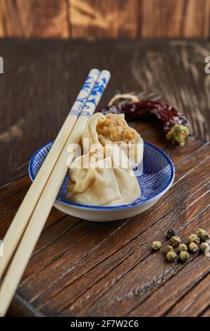 Shumai Shaomai Chinesisches Fleischknödel gedünstetes Gericht in Bambus-Dampfgarer-Box. Essstäbchen und Dimmen. Stockfoto