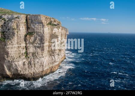 RABAT, MALTA - 10. Feb 2021: Kalksteinfelsen mit Sedimentgesteinsschichten an der Küste von Migra l-Ferha, Malta. Wellen treffen auf die BA Stockfoto