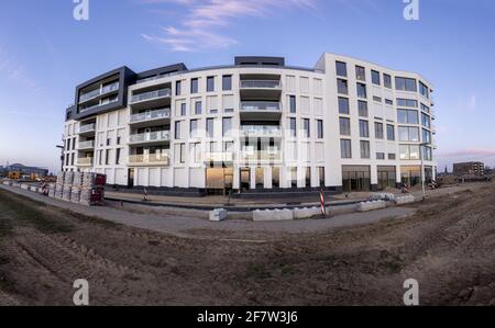 ZUTPHEN, NIEDERLANDE - Mar 30, 2021: Außenfassade des modernen Wohnbaukomplexes im Bau mit weißer Fassade, die von der Fassade beleuchtet wird Stockfoto