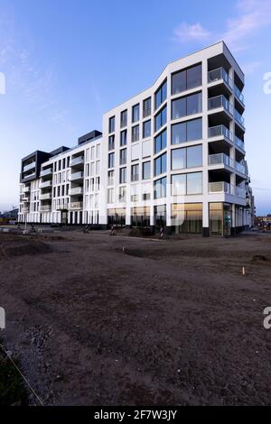 ZUTPHEN, NIEDERLANDE - Mar 30, 2021: Feldweg, auf dem eine Asphaltstraße vor dem modernen Gebäudekomplex mit moderner Wohnarchitektur geplant ist Stockfoto