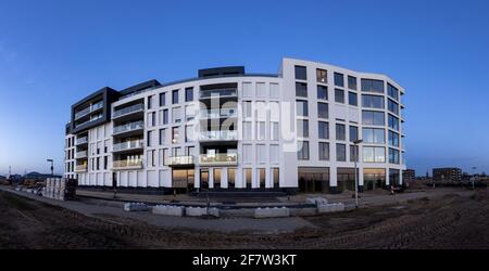 ZUTPHEN, NIEDERLANDE - Mar 30, 2021: Architektur von neu erbauten Luxus-Apartments mit Schotterebene im Vordergrund auf Infrastruktur warten Stockfoto