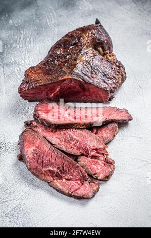 Gebratener Aufhänger oder Onglet-Rindersteak in Scheiben auf einem Tisch. Weißer Hintergrund. Draufsicht Stockfoto